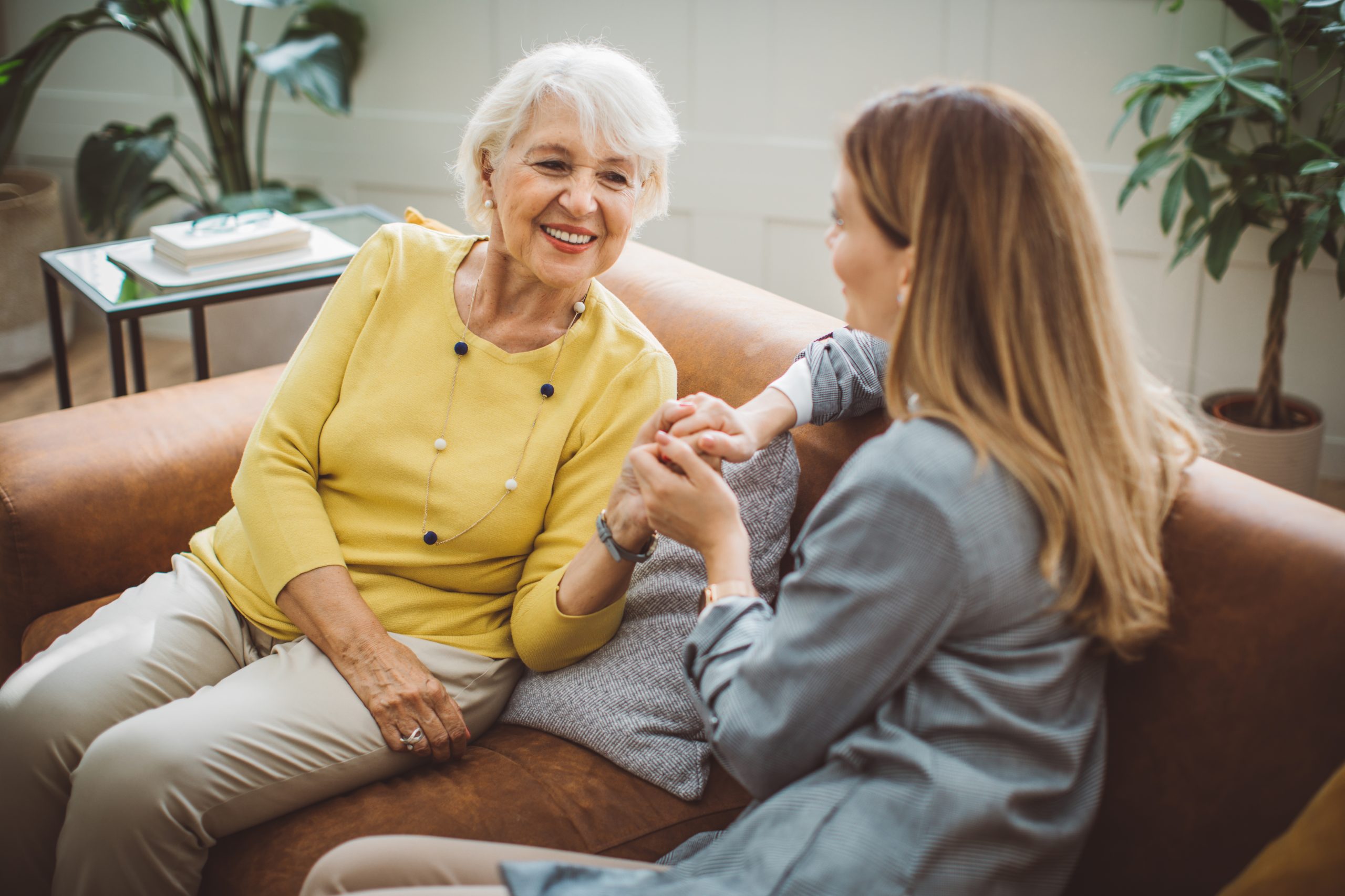 Manging parents' finances. Senior woman talking with her daughter at home.